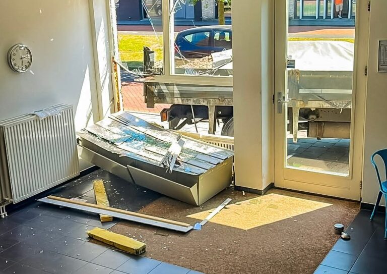 Mini-vrachtwagen rijdt gevel van woonvoorziening binnen