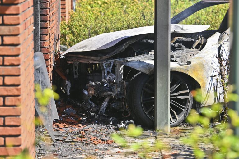 Auto botst tegen flat, vliegt in brand en bestuurder naar ziekenhuis
