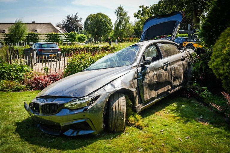 BMW slaat over de kop en eindigt in tuin