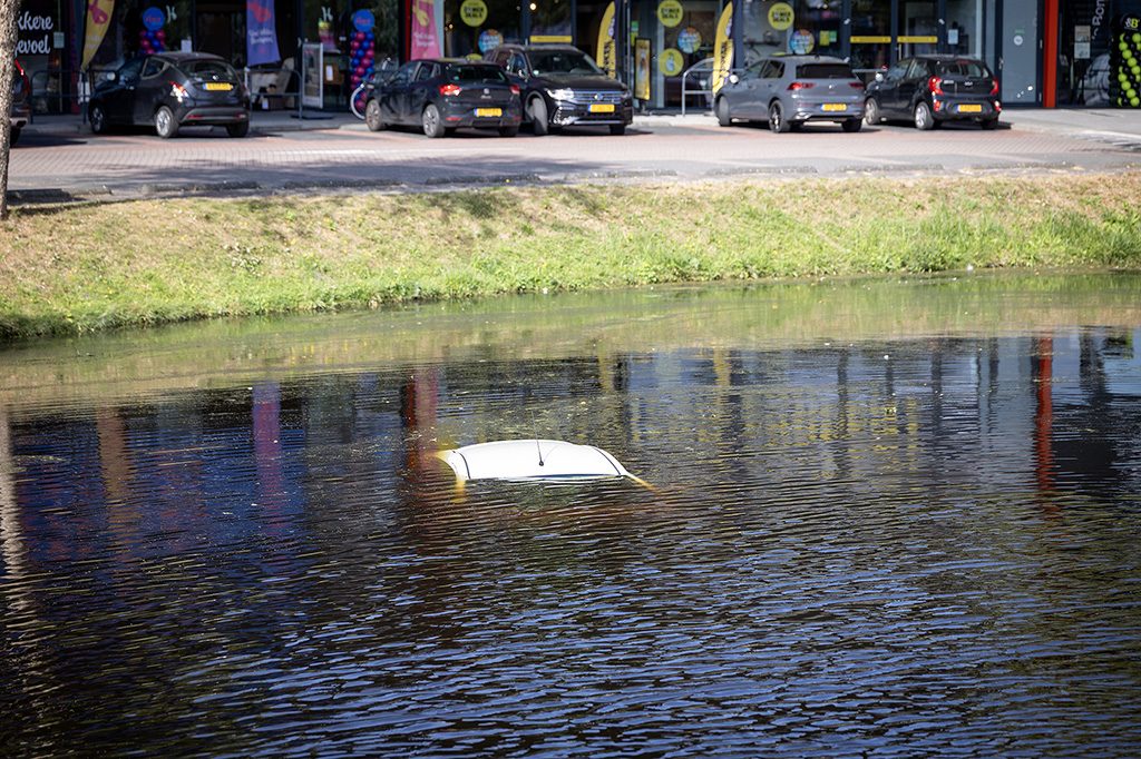 Auto rolt parkeerplaats af en belandt midden op het water