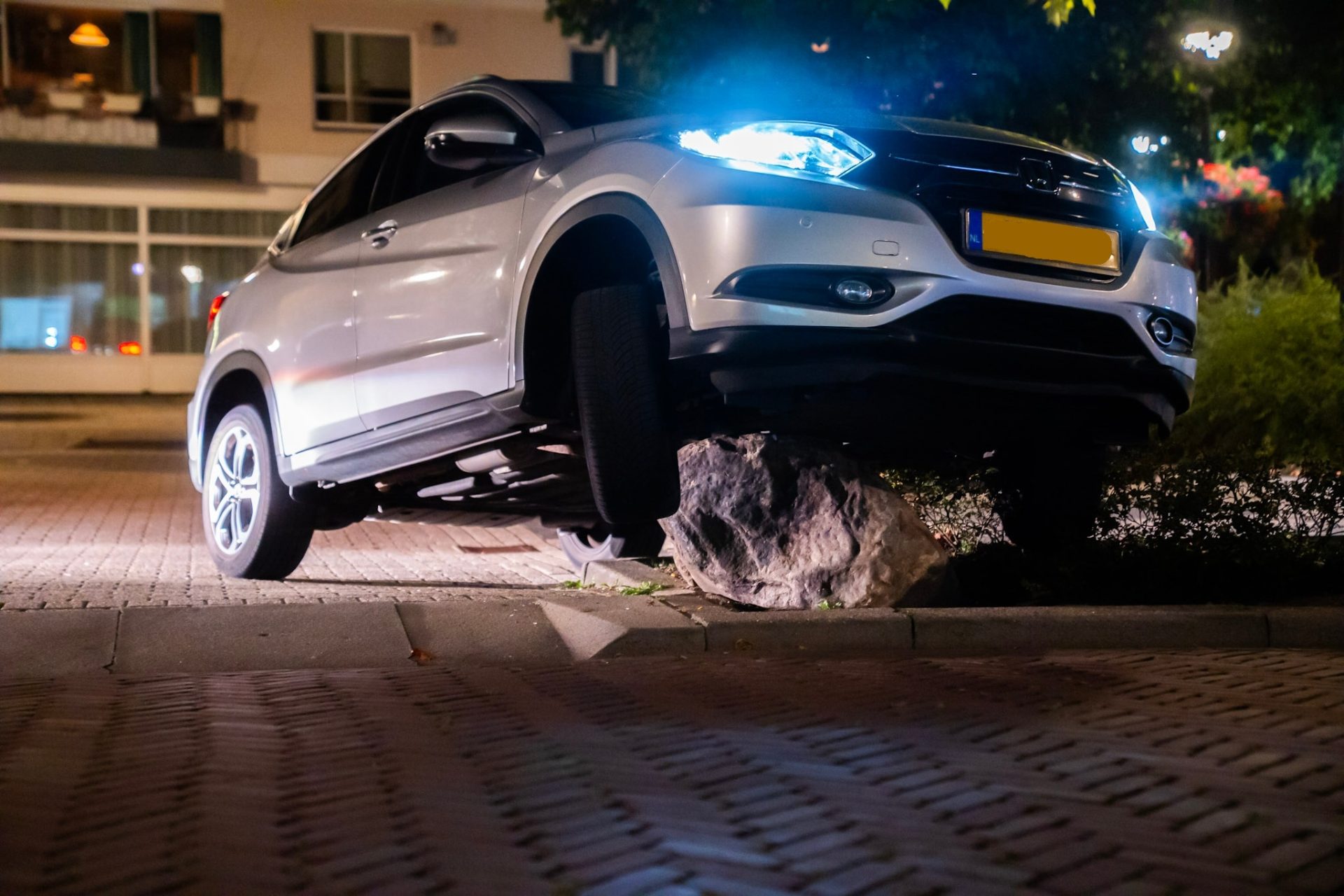 Vluchtende automobilist belandt met auto bovenop grote kei