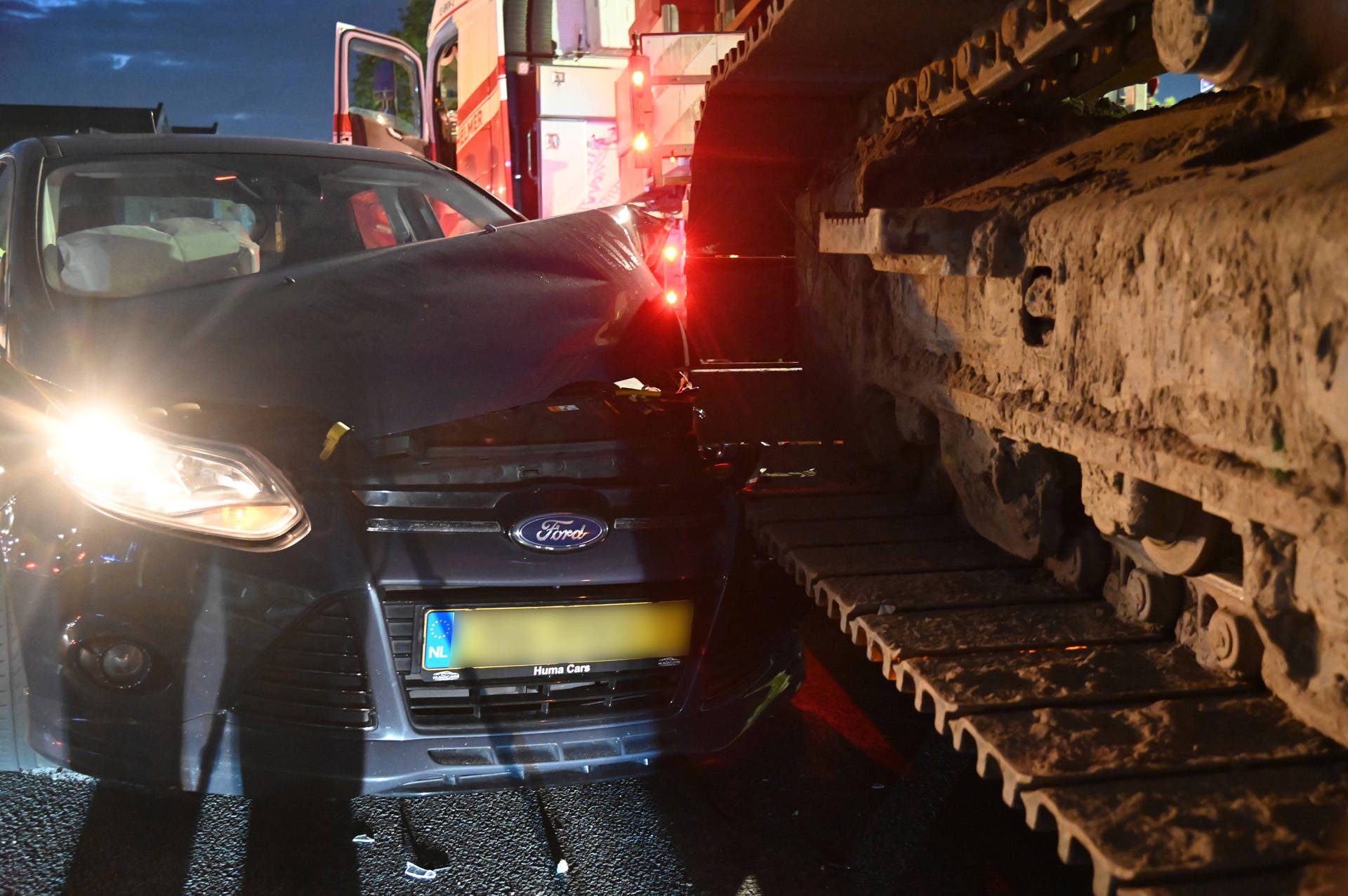 Automobilist botst tegen rupsband van graafmachine op dieplader