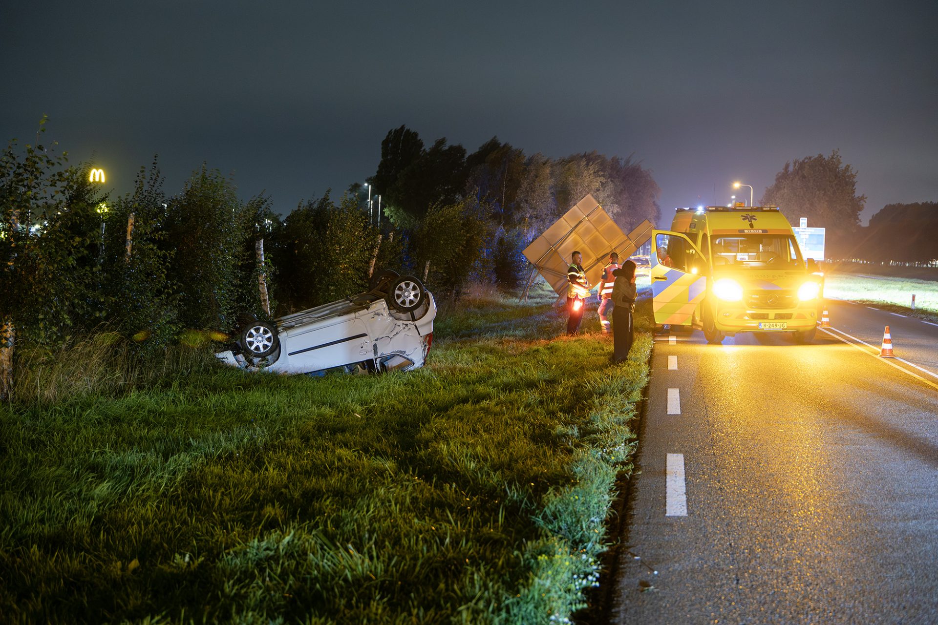 Auto ramt verkeersbord en slaat over de kop