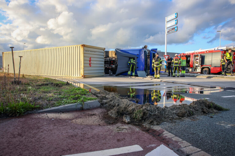 Vrachtwagen kantelt op rotonde, brandstoftank scheurt open