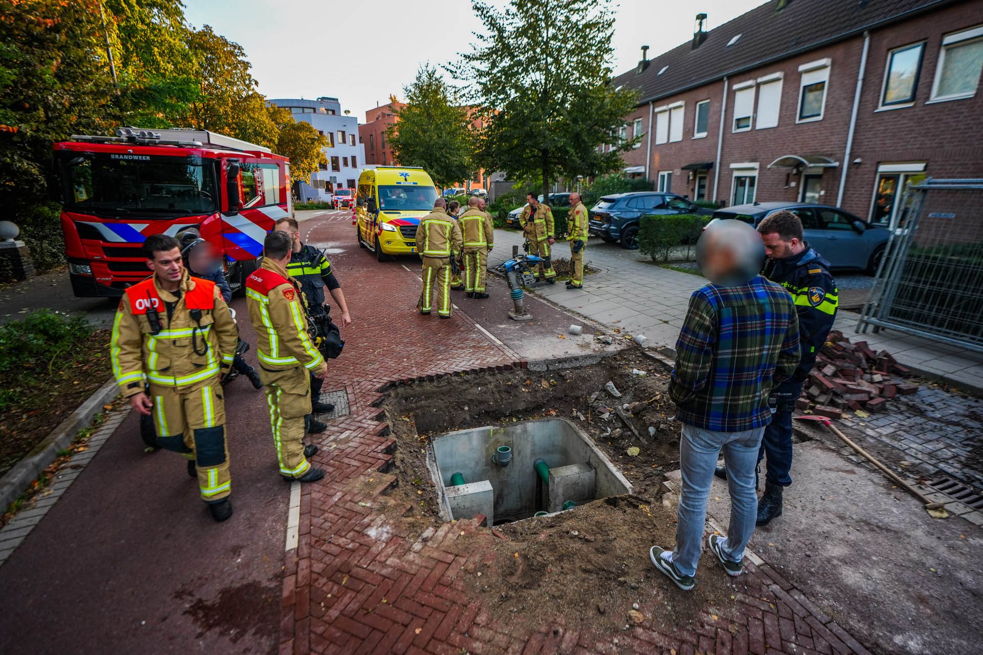 Vrouw fietst afgezette straat in en valt in diepe put