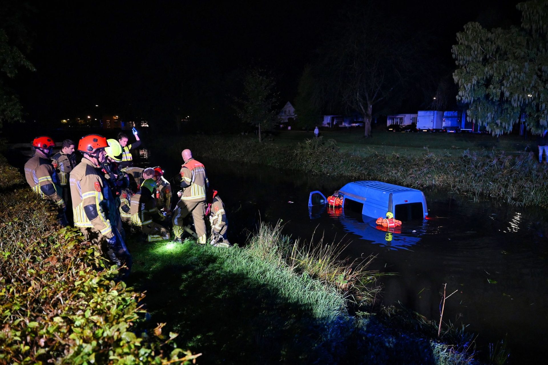 Invalidenbusje belandt in water in, brandweer redt inzittenden