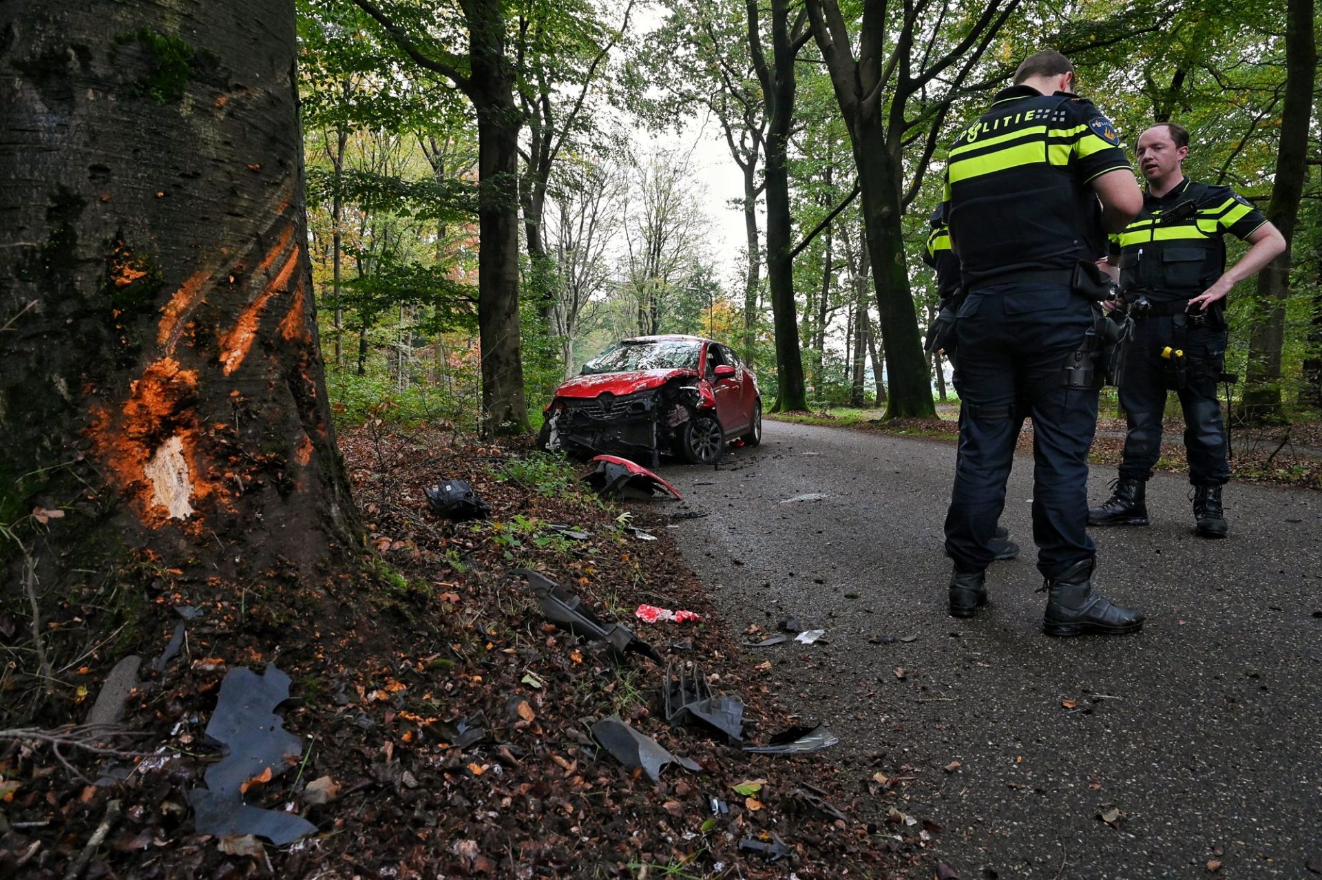 Auto slaat over de kop na botsing tegen boom, twee mannen gewond