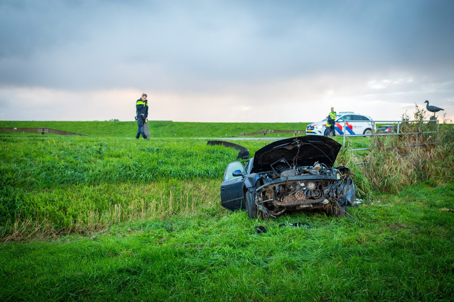 Automobilist gewond na ongeval, auto schiet meters door weiland