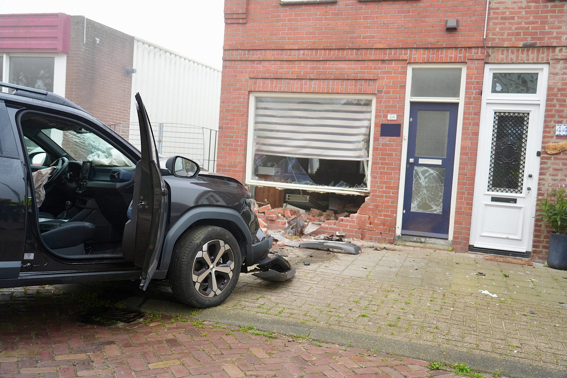 Automobilist rijdt door gevel, twee woningen ontzet