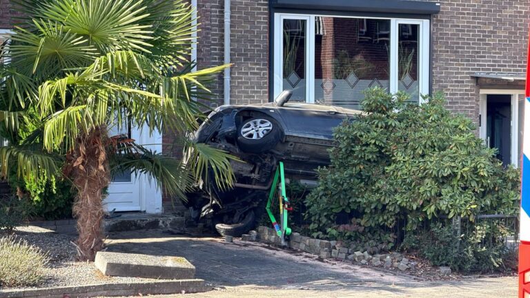 Auto belandt op zijn kant in voortuin