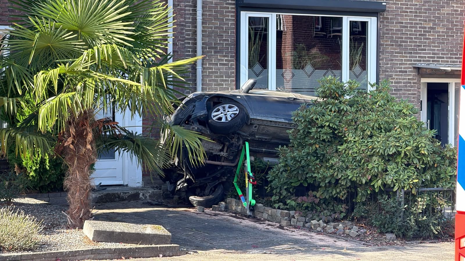 Auto belandt op zijn kant in voortuin